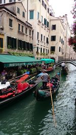 Boats in canal along buildings