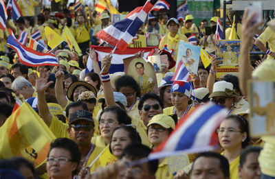 High angle view of people with picture frame and thai flags at event