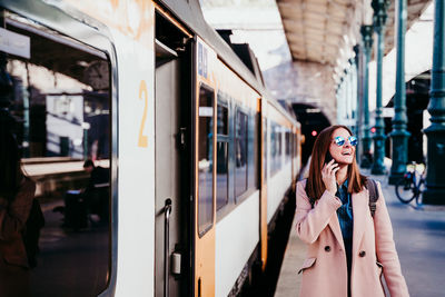 Woman standing on train at railroad station