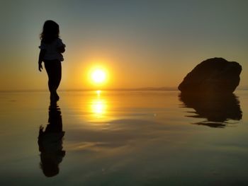 Full length of man standing on beach during sunset