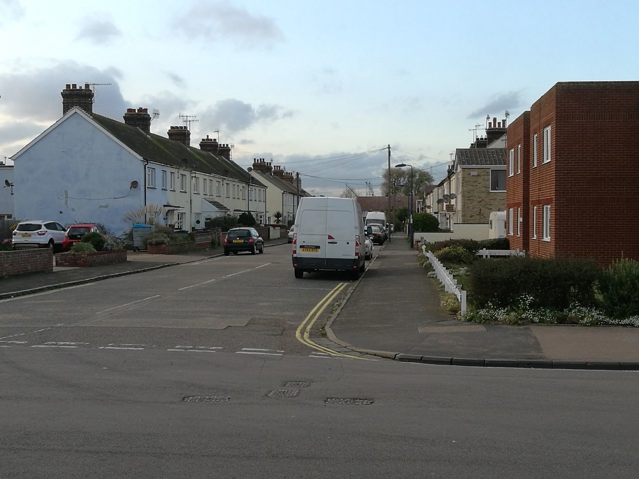 CARS ON ROAD BY BUILDINGS AGAINST SKY