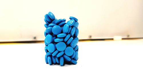 Digital composite image of blue pills on white table 