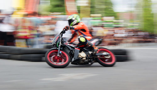 Blurred motion of person riding motorcycle on road