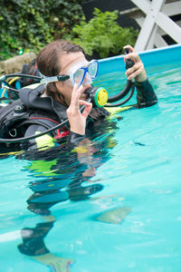 Tilt shot of woman scuba diving in swimming pool