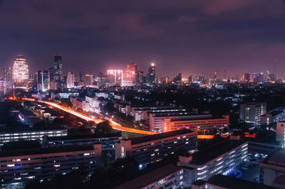 Illuminated cityscape against sky at night