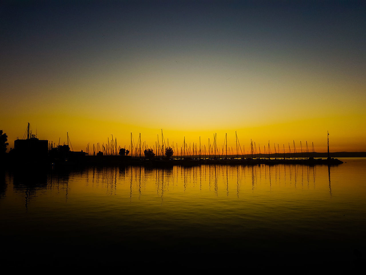 SAILBOATS IN SEA AT SUNSET