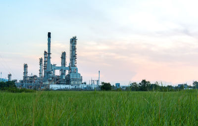 Panoramic view of factory against sky during sunset