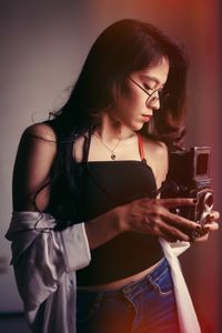 Young woman using camera at home