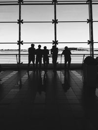 Rear view of silhouette people walking at airport