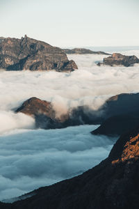 Highest rocky mountains of  madeira emerge from the clouds into the sunset from pico ruivo do paul.