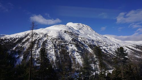 Low angle view of snowcapped mountains against sky