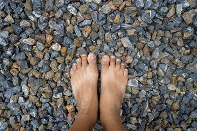 Low section of person standing on stones