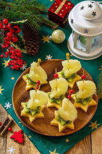 Festive snack of canapes on the christmas table. fruit canapes with cheese, kiwi and pineapple.