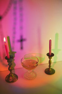 Colorful spell scene of wine and candles with cross rosary out of focus