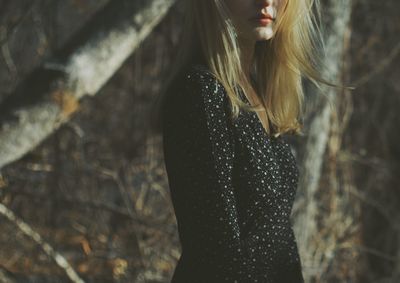 Midsection of woman with blond hair standing outdoors