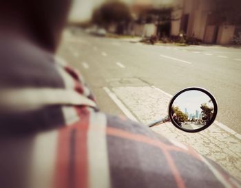 Reflection of person on side-view mirror