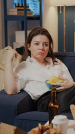 Portrait of young woman sitting on table