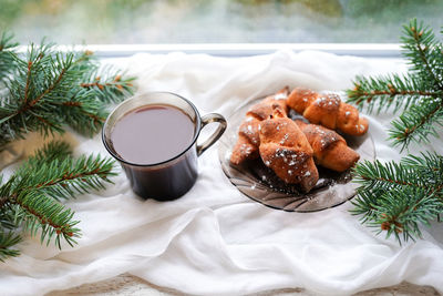 Christmas still life  coffee, fir tree branches on a wooden background on winowsill