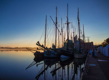 Sailboats moored in lake against sky