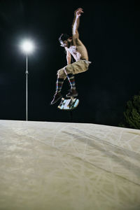 Young white man jumping on his skateboard