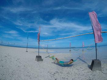 Clothes hanging on beach against sky