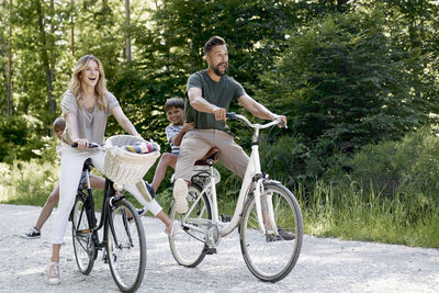 Happy parents giving ride to children on bicycle