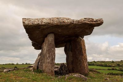 Stone structure on field against sky