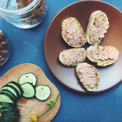 High angle view of pate and sliced cucumber on table