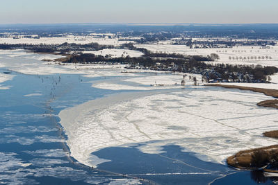 High angle view of snow covered cityscape against sky