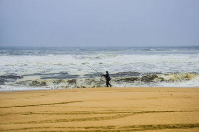 Man standing on beach against sky