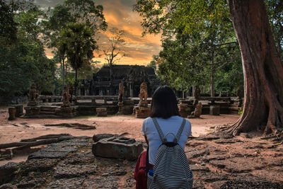 Rear view of woman standing at temple against sky