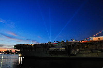 Boats against clear blue sky at night