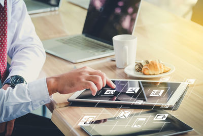 Close-up of man using laptop on table