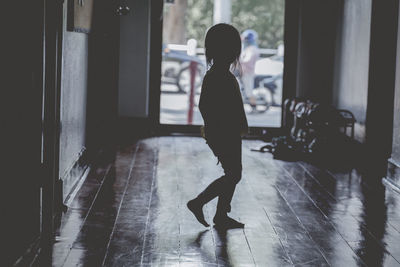 Side view of silhouette woman standing on floor at home