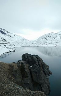 Scenic view of lake by mountain against sky