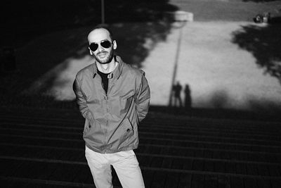 Portrait of mid adult man wearing sunglasses standing on steps