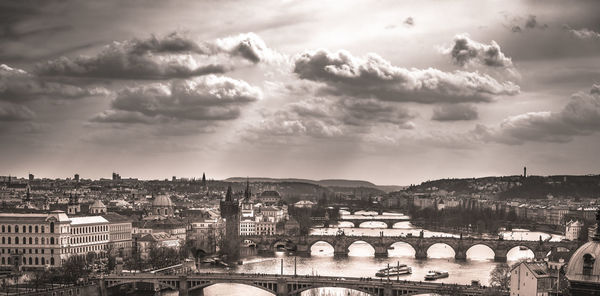 Charles bridge over vltava river against sky in city