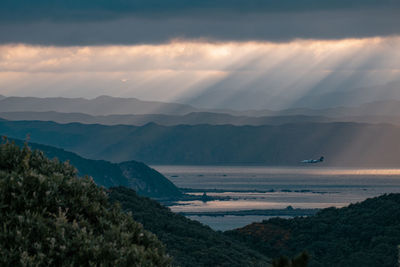 Scenic view of sea and mountains against sky