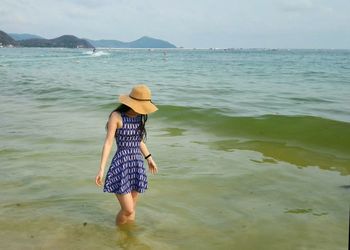 Rear view of woman standing on beach