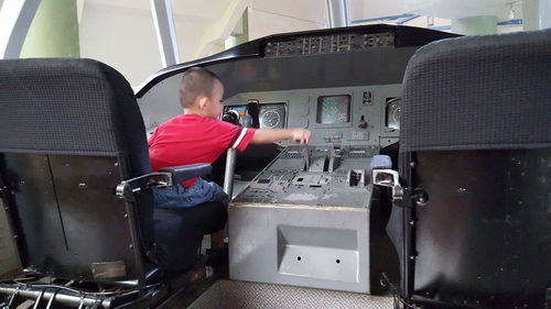 Rear view of man working at airplane