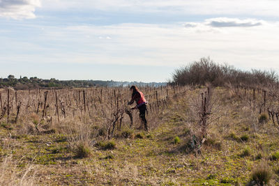 Woman standing on field against sky