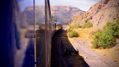 Train on railroad track by mountains against sky