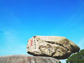 Low angle view of chinese script on rock at mount putuo