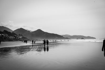 People on beach against sky