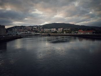 River by buildings against sky in city