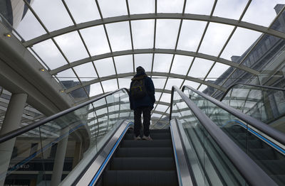 Low angle view of man walking on escalator