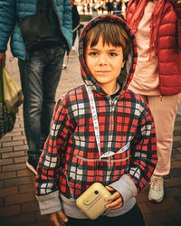 Portrait of young man standing against wall