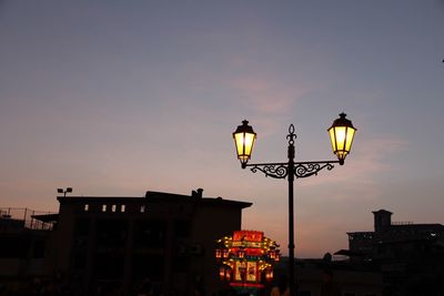 Low angle view of illuminated street light against sky