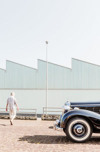 Man driving car against clear sky