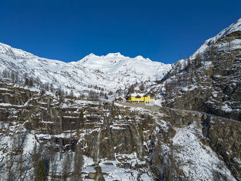 Scenic view of snowcapped mountains against clear blue sky